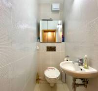 Badezimmer mit Spiegel, Waschbecken und Toilette in einer 3-Zimmer-Wohnung.