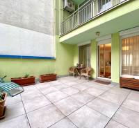 Eine Terrasse mit Liegestühlen und Pflanzen bei einer 3-Zimmer-Wohnung mit Zugang zum Balkon.