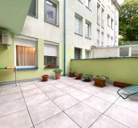 Terrasse mit Blumentöpfen und Liegestuhl in einer 3-Zimmer-Wohnung.