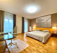 Schlafzimmer in einer 3-Zimmer-Wohnung mit einem großen Bett, einem Tisch und Parkettboden.