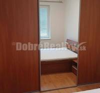 Schlafzimmer mit Holzboden und Schrank in einer 2-Zimmer-Wohnung.
