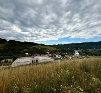 Hügelige Landschaft in Divinka mit Blick auf Grundstücke - Wohnen unter bewölktem Himmel.