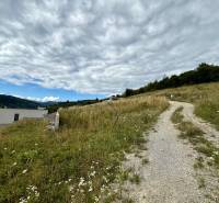 Grundstücke - Wohnen in Divinka mit ländlicher Straße und Panoramablick auf die Landschaft.
