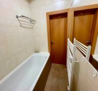 Badezimmer mit Badewanne, Fliesen und weißen Fliesen in einer 2-Zimmer-Wohnung.