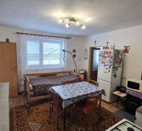 Küche in einem Einfamilienhaus mit Esstisch, Bett und Geräten.