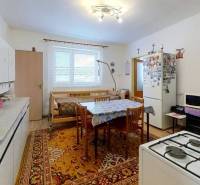 Küche in einem Einfamilienhaus mit Esstisch, Gasherd und Teppichen.