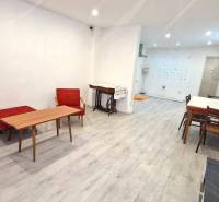 Wohnzimmer mit Holzmöbeln und weißen Wänden in einem Einfamilienhaus.