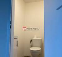 Toilette in einem weißen Raum mit einer Toilettenschüssel und einem Waschbecken. Geschäftsräume.