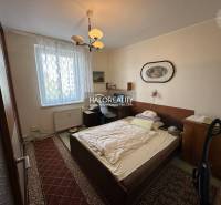 Schlafzimmer in einer 3-Zimmer-Wohnung mit Bett, Bild und Teppichen, geeignet zum Wohnen.