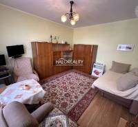 Wohnzimmer in einer 3-Zimmer-Wohnung mit Sesseln, Teppich und Schrank.