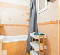 Badezimmer mit Badewanne, Waschbecken und Stauraum in einer 2-Zimmer-Wohnung.