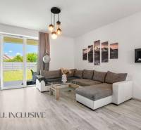 Wohnzimmer eines Einfamilienhauses mit einem bequemen Sofa und Glastüren zum Garten.