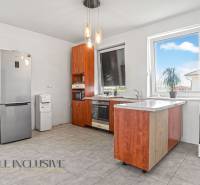 Küche mit Holzschränken, Kühlschrank und Geräten im Einfamilienhaus.