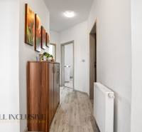 Der Flur in einem Einfamilienhaus mit einer Holzkredenz und einem bunten Bild an der Wand.
