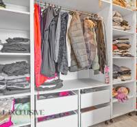 Ein Kleiderschrank im Einfamilienhaus mit Kleidung, Spielzeug und gelagerten Gegenständen in Regalen und Schränken.