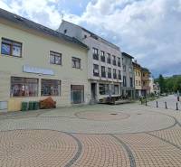 Das Gebäude in der Mostová-Straße in Ružomberok mit einem gepflasterten Platz und umliegender Infrastruktur.