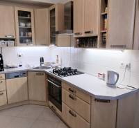 Küche in einer 4-Zimmer-Wohnung mit Holzschränken und modernen Geräten.