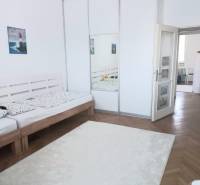 Helles Schlafzimmer mit großem Kleiderschrank und Holzbett in einer Vierzimmerwohnung.