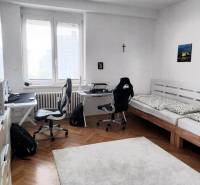Ein Zimmer mit zwei Schreibtischen und einem Bett in einer 4-Zimmer-Wohnung.