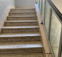 Eine Treppe mit Glasgeländer führt zu einem Fenster in einer 4-Zimmer-Wohnung.