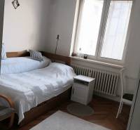 Schlafzimmer mit Bett, Lampe und Fenster in einer 4-Zimmer-Wohnung.