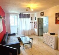 Wohnzimmer in einer 3-Zimmer-Wohnung mit roter Wand, Sofa und dekorativen Möbeln.