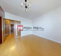 Ein Zimmer mit Holzboden, Einbauschrank und Beleuchtung in einer 3-Zimmer-Wohnung.