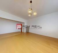 Ein geräumiges Zimmer mit Holzboden und einer Leuchte in einer 3-Zimmer-Wohnung.