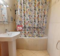 Badezimmer mit Waschbecken und Badewanne mit gemustertem Duschvorhang in einer 3-Zimmer-Wohnung.