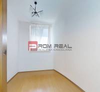 Leerer Raum mit weißen Wänden, Laminatboden und Fenster in einer 3-Zimmer-Wohnung.