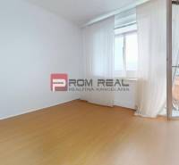 Ein leeres Zimmer in einer 3-Zimmer-Wohnung mit Laminatboden und Balkon.