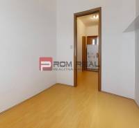 Ein Zimmer mit Holzboden und weißen Wänden in einer 3-Zimmer-Wohnung.
