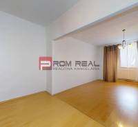 Innenraum einer 3-Zimmer-Wohnung mit Laminatboden und Vorhängen am Fenster.