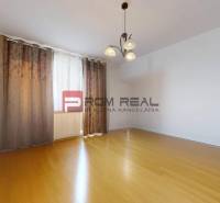 Ein leerer Raum mit Holzboden und Vorhängen, 3-Zimmer-Wohnung.