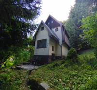 Hütte im Wald in Kordíky, Banská Bystrica, umgeben von Grün und Bäumen.
