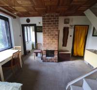 Wohnbereich in einer Hütte mit Kamin, einfacher Möblierung und Boden mit Holzdekor.