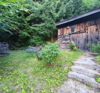 Eine Holzhütte umgeben von Grün in Kordíky in Banská Bystrica.