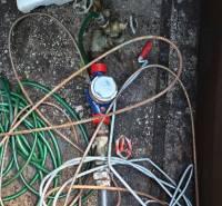Wasserventil mit einem Gewirr von Schläuchen im Heizraum der Hütte.