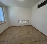 Ein leerer Raum mit Holzboden und zwei Fenstern in einer 3-Zimmer-Wohnung.