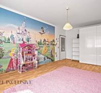 Kinderzimmer mit Märchentapete in einer 2-Zimmer-Wohnung, weiße Möbel und rosa Teppich.