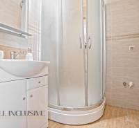 Badezimmer mit Waschbecken und Duschkabine in einer 2-Zimmer-Wohnung.