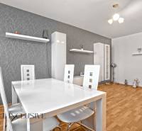Esszimmer in einer 2-Zimmer-Wohnung mit Holzboden und weißen Möbeln.