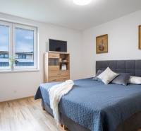 Schlafzimmer im Einfamilienhaus mit Ehebett, Bildern und Fenster.