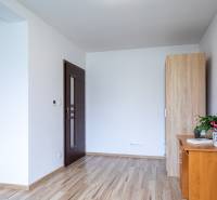 Innenraum eines Einfamilienhauses mit Holzboden, Möbeln und einer Zimmerpflanze auf dem Tisch.