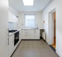 Küche mit weißen Schränken, Geräten und einem Fenster in einem Einfamilienhaus.