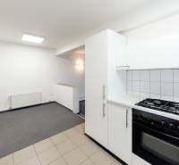 Küche mit weißen Schränken, Elektroherd und Kochfeld in einem Einfamilienhaus.