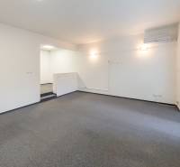Wohnzimmer in einem Einfamilienhaus mit Teppichboden, Klimaanlage und Zugang zur Terrasse.