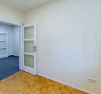 Ein Zimmer in einem Einfamilienhaus mit Holzboden, weißen Türen und einem Teppich.