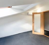 Dachzimmer in einem Einfamilienhaus mit Holztüren und Glaseinsatz.