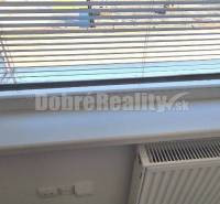 Jalousien am Fenster im Büro mit Heizkörper und Teppich.
